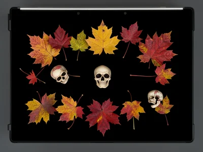 Flatbed scan of autumn leaves and small decorative skulls, arranged composition