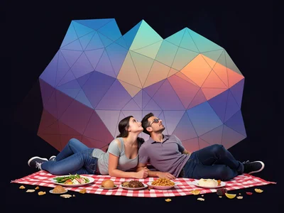 Couple lying on picnic blanket looking up at sky, scattered food around them