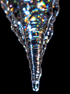 Icicle tip extreme macro showing internal structure, light refracting through la