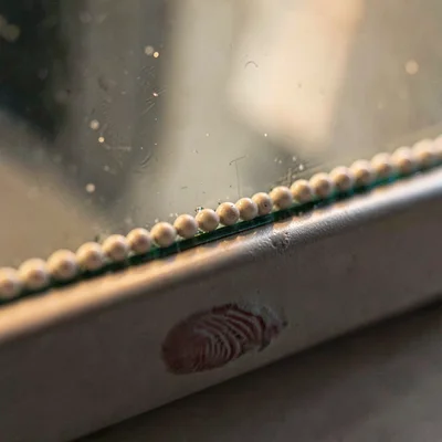 Macro of a beaded sealant line along a glazing stop with a single fingerprint sm