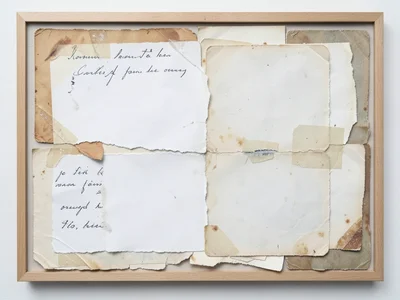 Collage of torn photographs layered face-down, only the white backs visible with