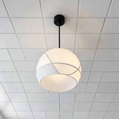 Spherical pendant light against white ceiling grid, minimal shadow