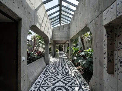 Interior corridor lit by a band of clerestory glass, mosaic tile floor in geomet
