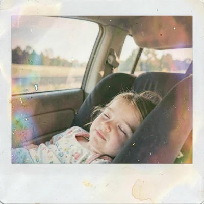 Expired Polaroid instant film photograph, Child sleeping in car seat during road