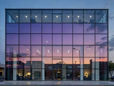 Full facade as gradient canvas at dusk