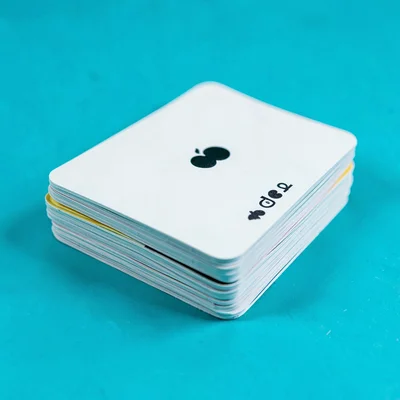 deck of minimal-print playing cards stacked in a tight pile top-down on a satura