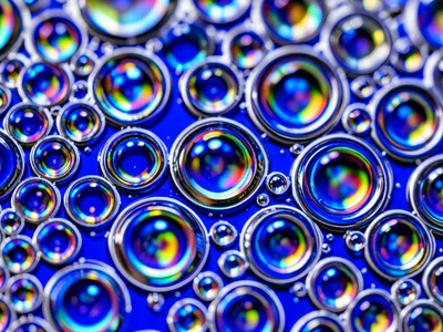 Oil on water with blue gel beneath, cobalt blue shining through each transparent