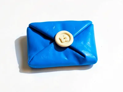 Vibrant chunky clay envelope letter in primary blue with stubby cream-toned wax