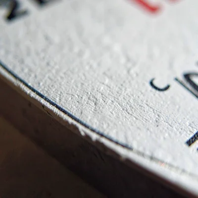 Mineral close-up of an ink bottle label edge with subtle paper grain (no readabl