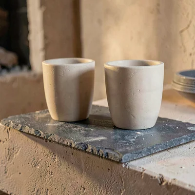 Vertical slate composition of a kiln shelf with two upright bisque cups