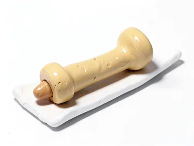 Skinny chunky clay drumstick in cream-tan with stubby tip and oversized squat ha