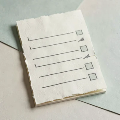 Papercraft hero of a layered paper grocery list with paper tick marks at the sid
