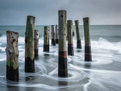 Pier pilings with water flowing past as silk