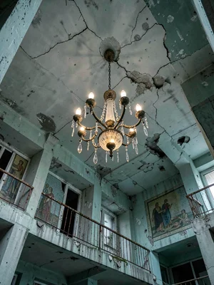Lobby Chandelier Hanging Askew from Crumbling Plaster