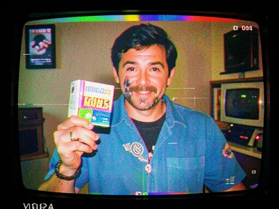 A late-night infomercial host holding up a product, face smeared by pause artifa
