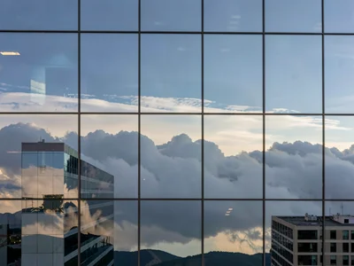 Building disappearing into reflected clouds