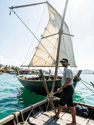Brilliant Indian Ocean noon light in Dar es Salaam, Dhow captain steering, sail 