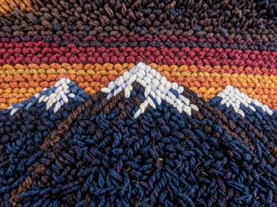 A mountain range at sunset with snow-capped peaks rendered in deep-pile shag car