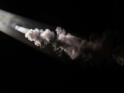 Smoke in light beam surrounded by dark