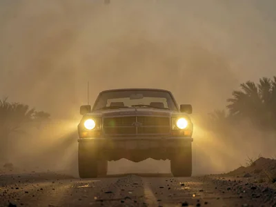 Car headlights glowing with halos through evening dust