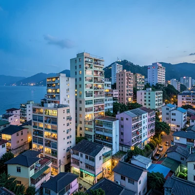 Busan vertical density, hillside village stacking, evening lights coming on in s