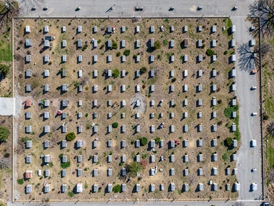 Cemetery from directly above, headstone grid casting tiny shadows