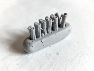 Scuffed putty-grey toothbrush with a slumped neck and fingernail dents along its