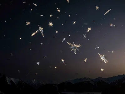 Ice crystals in thin air catching last light against darkening void