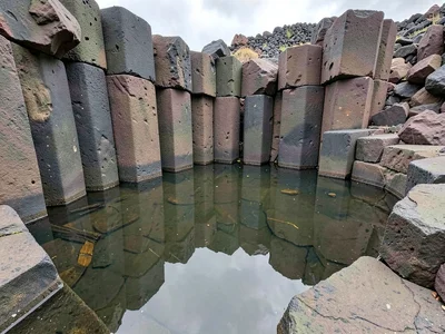 Basalt columns reflected in still tidal pool