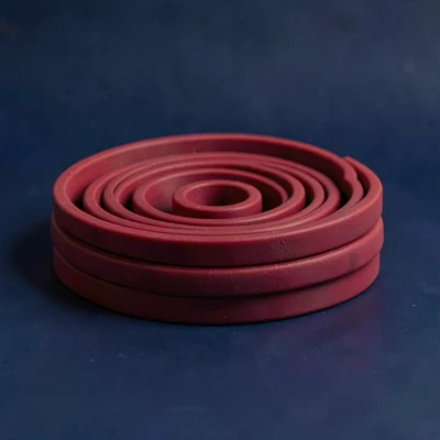 compact resistance band coil in scarlet stretched lightly straight-on against a