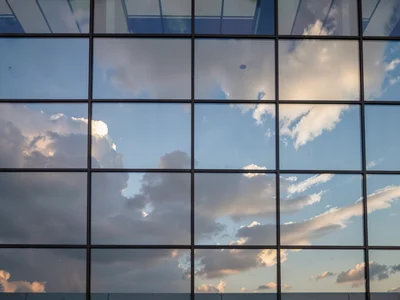 Reflected clouds moving across static facade