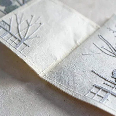Paper close-up of a textured gatefold sleeve open across a counter