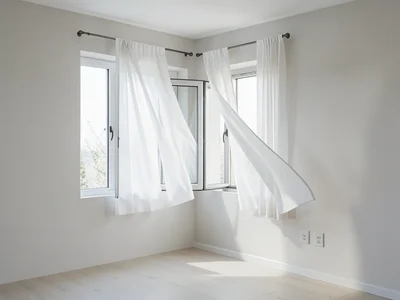 Open windows with white curtains billowing in spring breeze, clean room