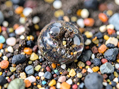 Volcanic glass grain with bubble inclusions