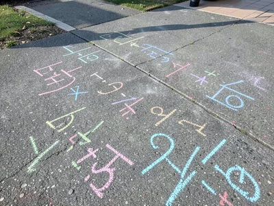 Numbers and math equations in chalk on a schoolyard, the teacher's lesson still 