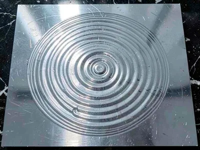 Water surface on metal plate showing circular standing wave pattern from 432Hz t