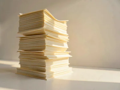 Towering stack of intricately folded cream paper documents arranged like a minia