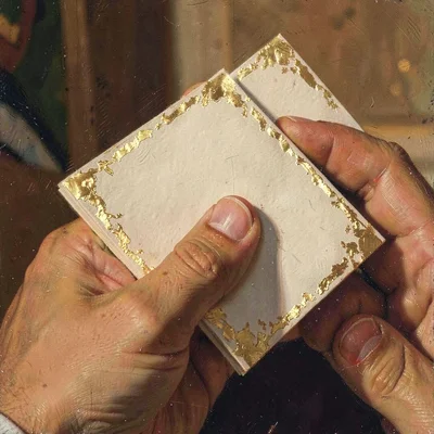 Warm painted close-up of a hand cradling a folded card, gold-leaf flecks catchin