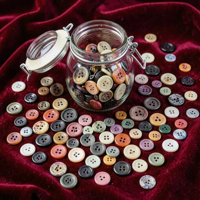 A grandmother's button jar contents spread on velvet, hundreds of buttons