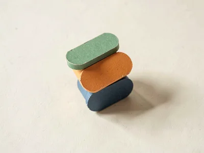 Stacked rounded papercraft blocks teetering slightly to one side, each block a d