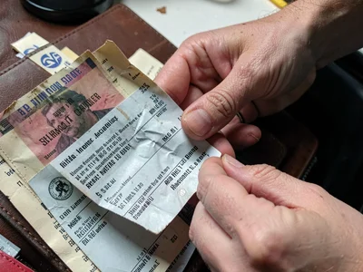 Person smoothing crumpled receipt for return, the proof of purchase restoration