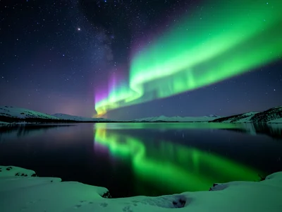 Aurora reflected in a perfectly still arctic lake, doubled display connecting sk