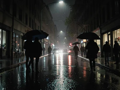 Rainy night street with umbrella silhouettes