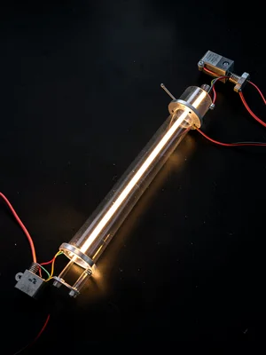 A single illuminated glass tube section lying on a black surface, no housing