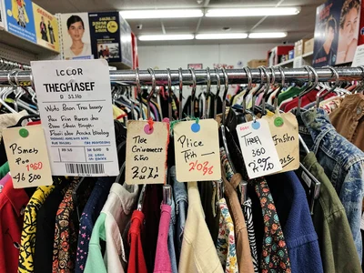 Price tags handwritten, colored dots indicating discounts, the thrift store pric