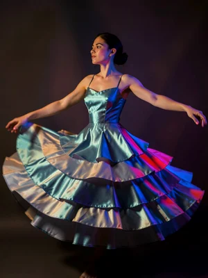 A model spinning in a layered silk dress, each layer of fabric catching differen