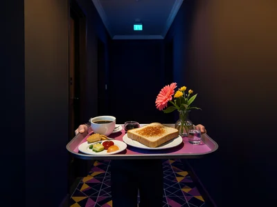Breakfast tray being carried down hallway, coffee, toast, flower in vase