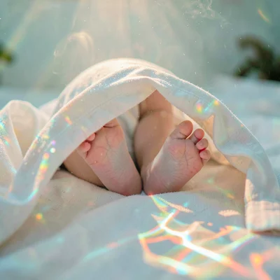 Soft diffused tropical light filtering through water vapor, Baby feet poking out