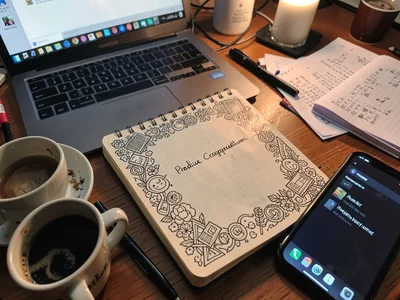 Notebook with elaborate doodle margin surrounding single written sentence