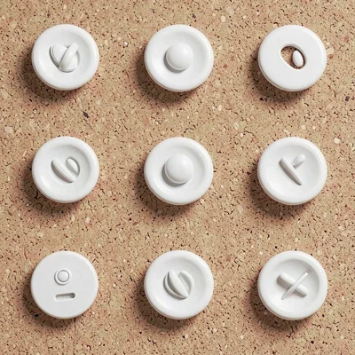 A 4x3 grid of abstract pin-button mockups on a soft cork backdrop, buttons sligh